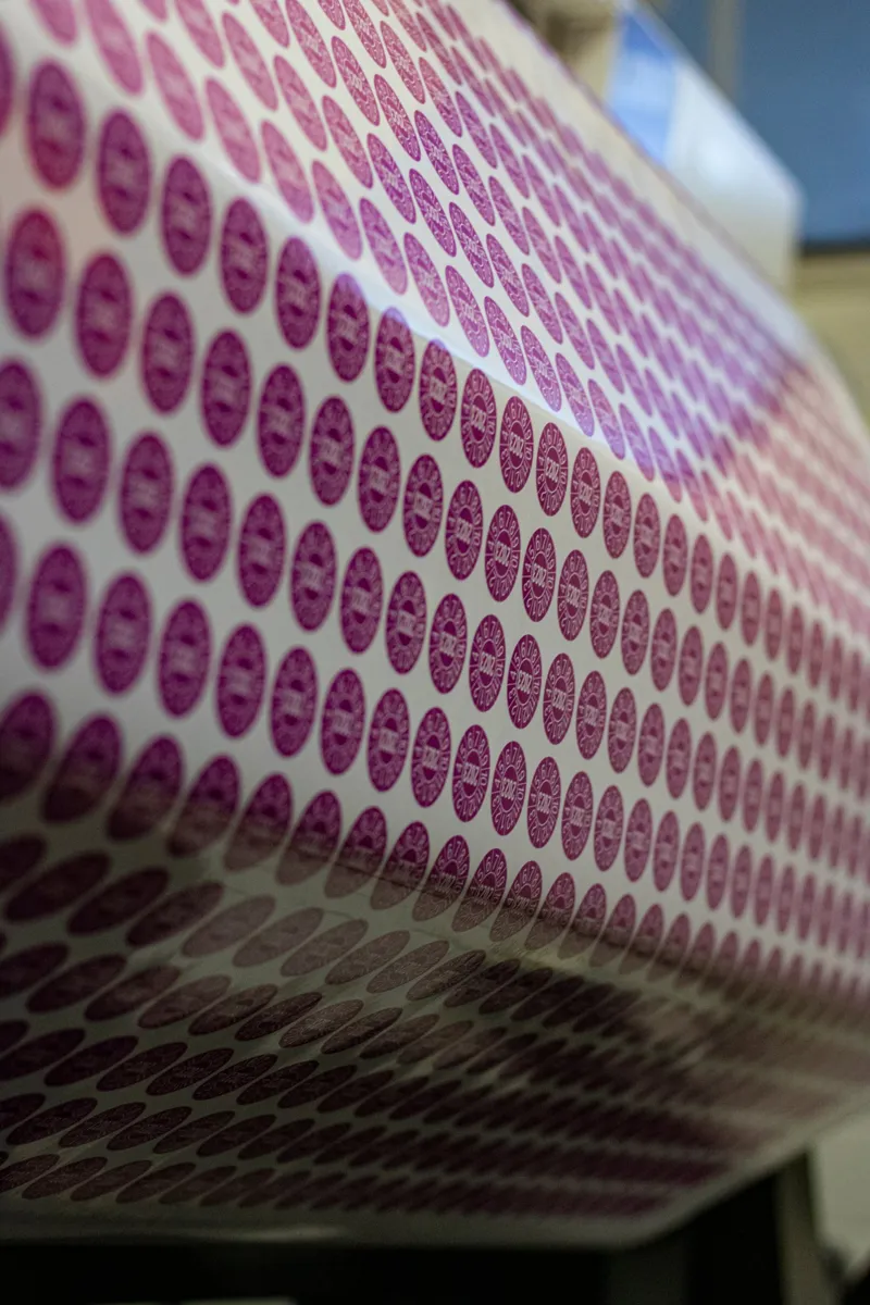 Runde Prüfplaketten in Magenta auf einem Druckbogen
