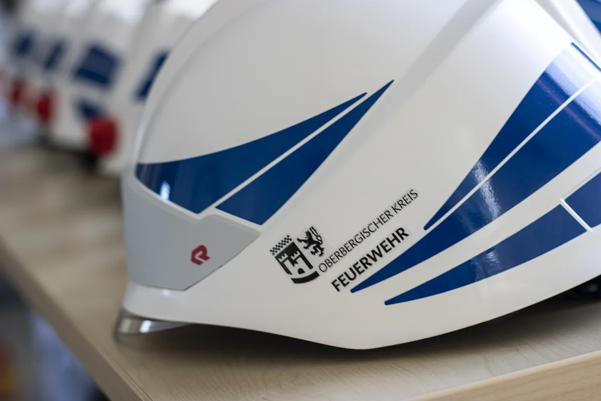 Feuerwehrhelme mit geschnittenen Dekorstreifen und Wappenaufkleber